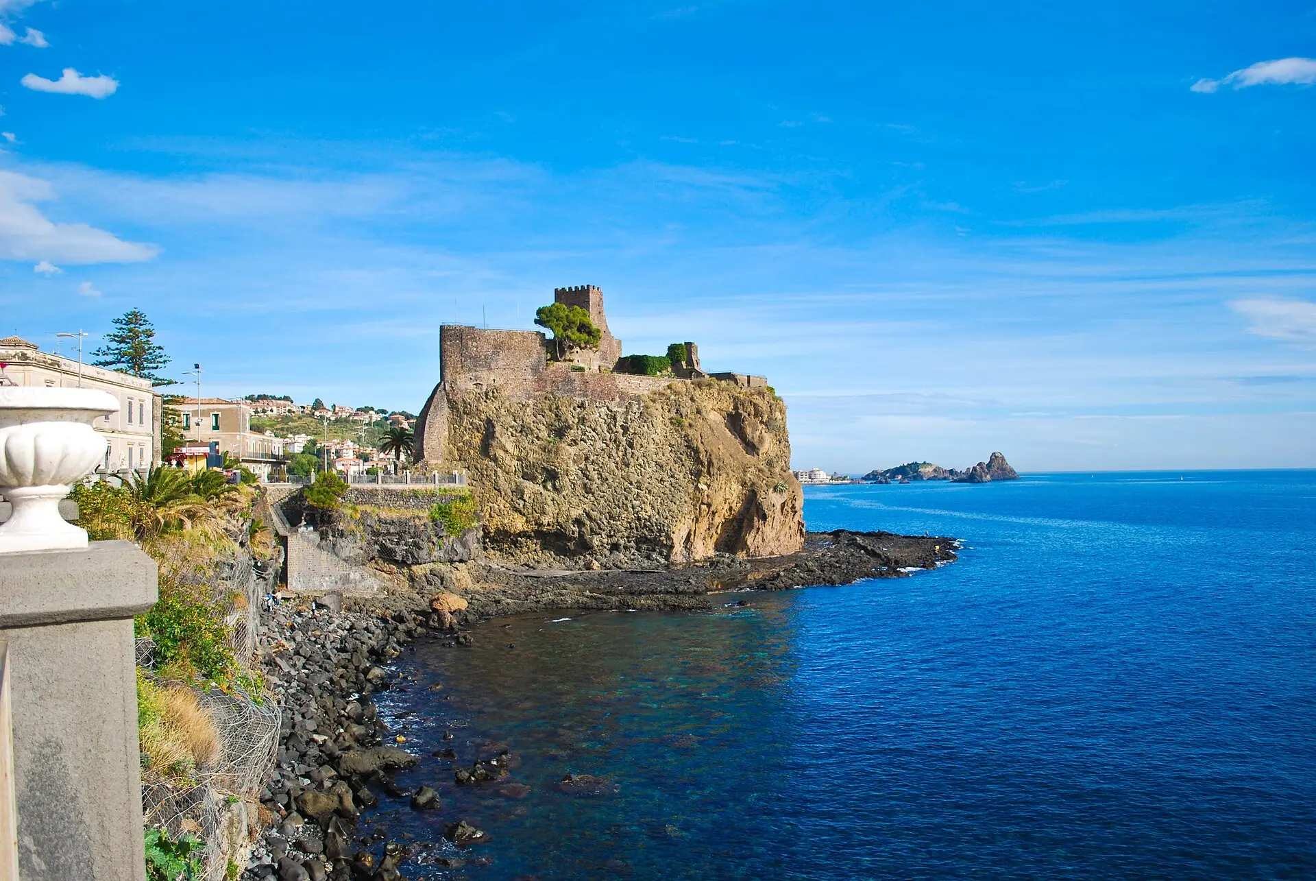 The Norman castle of Aci Castello standing on a black basalt crag above the sea