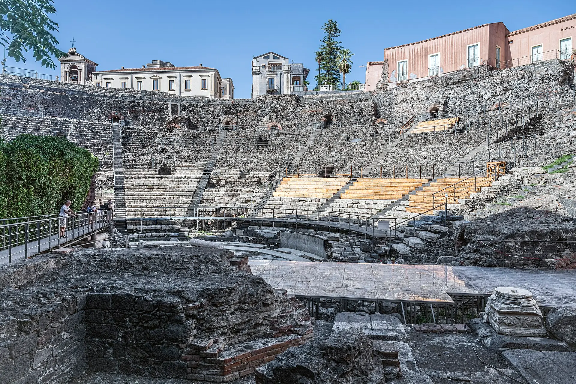 The stone tiers of the Roman theatre of Catania with houses built around its edge