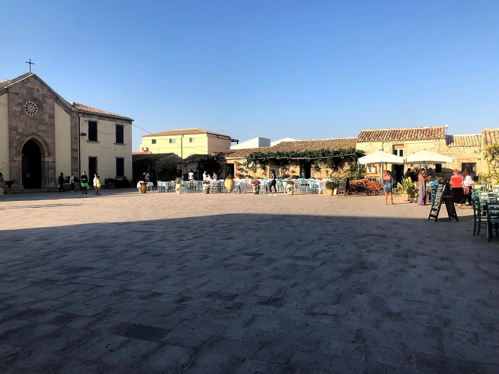 The main square of Marzamemi with old tuna-fishery buildings and tables set outside
